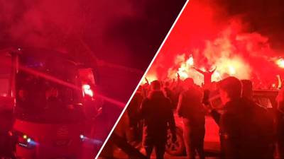 Uitzinnige PSV-fans onthalen spelers met rode fakkels en vuurwerk na historische voetbalavond